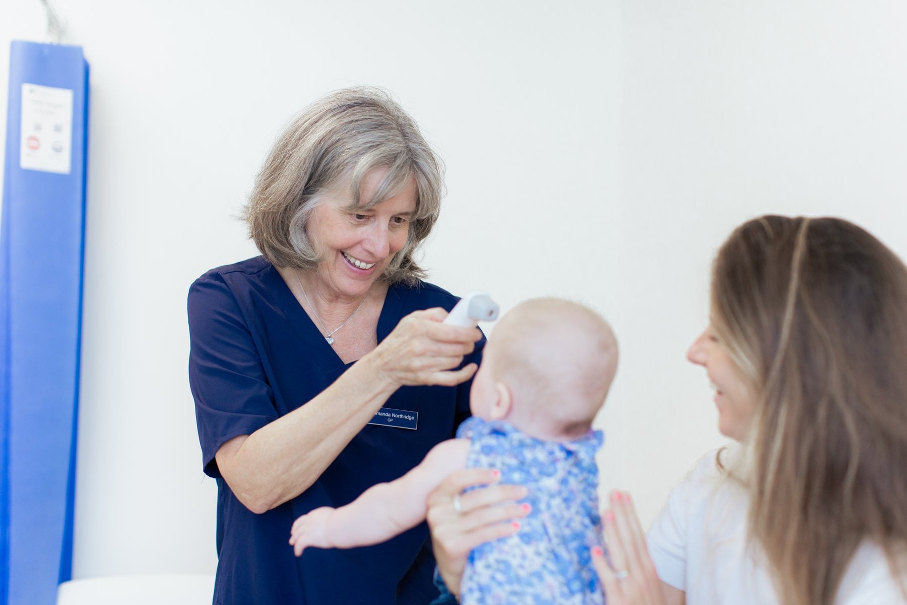 A Mayfield Clinic GP examining a baby with its mother